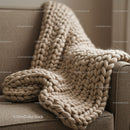 Chunky knit beige blanket draped over sofa armrest