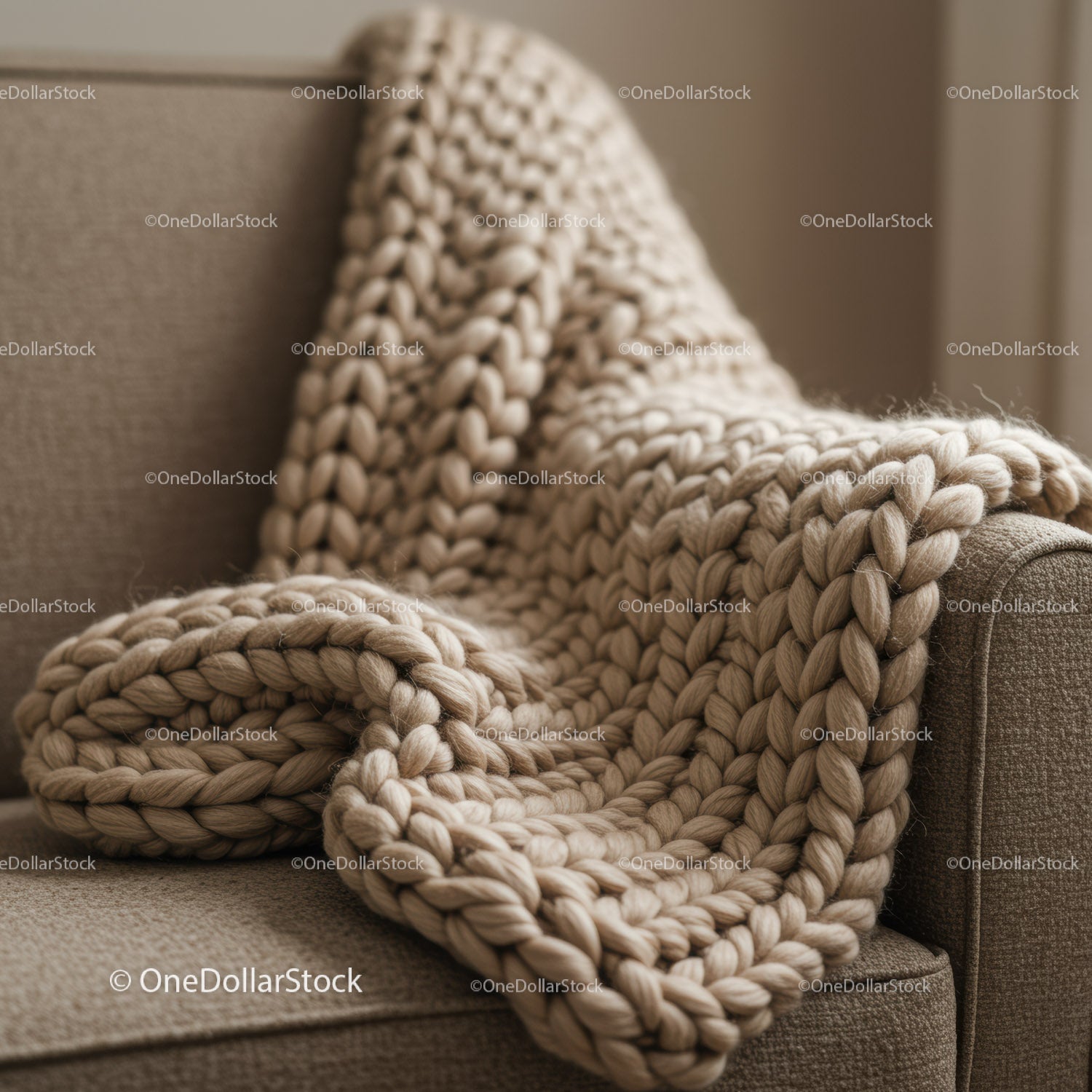 Chunky knit beige blanket draped over sofa armrest