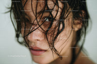 Close-up of a Woman with Wet Hair and Water Droplets in Natural Setting
