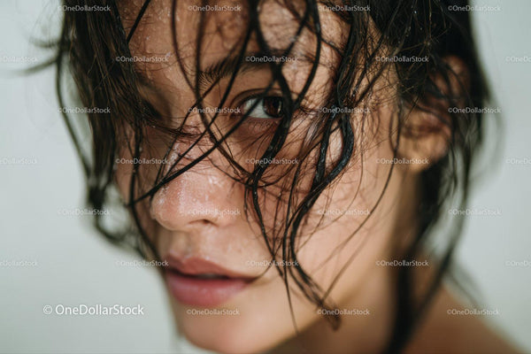 Close-up of a Woman with Wet Hair and Water Droplets in Natural Setting