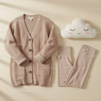 Cozy beige knit cardigan with soft leggings and pillow