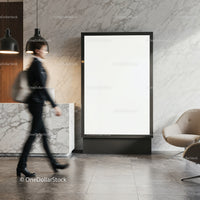 Professional woman walking past blank billboard in lobby