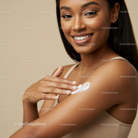 Portrait of a Beautiful Woman Smiling While Applying Sunscreen on Her Shoulder
