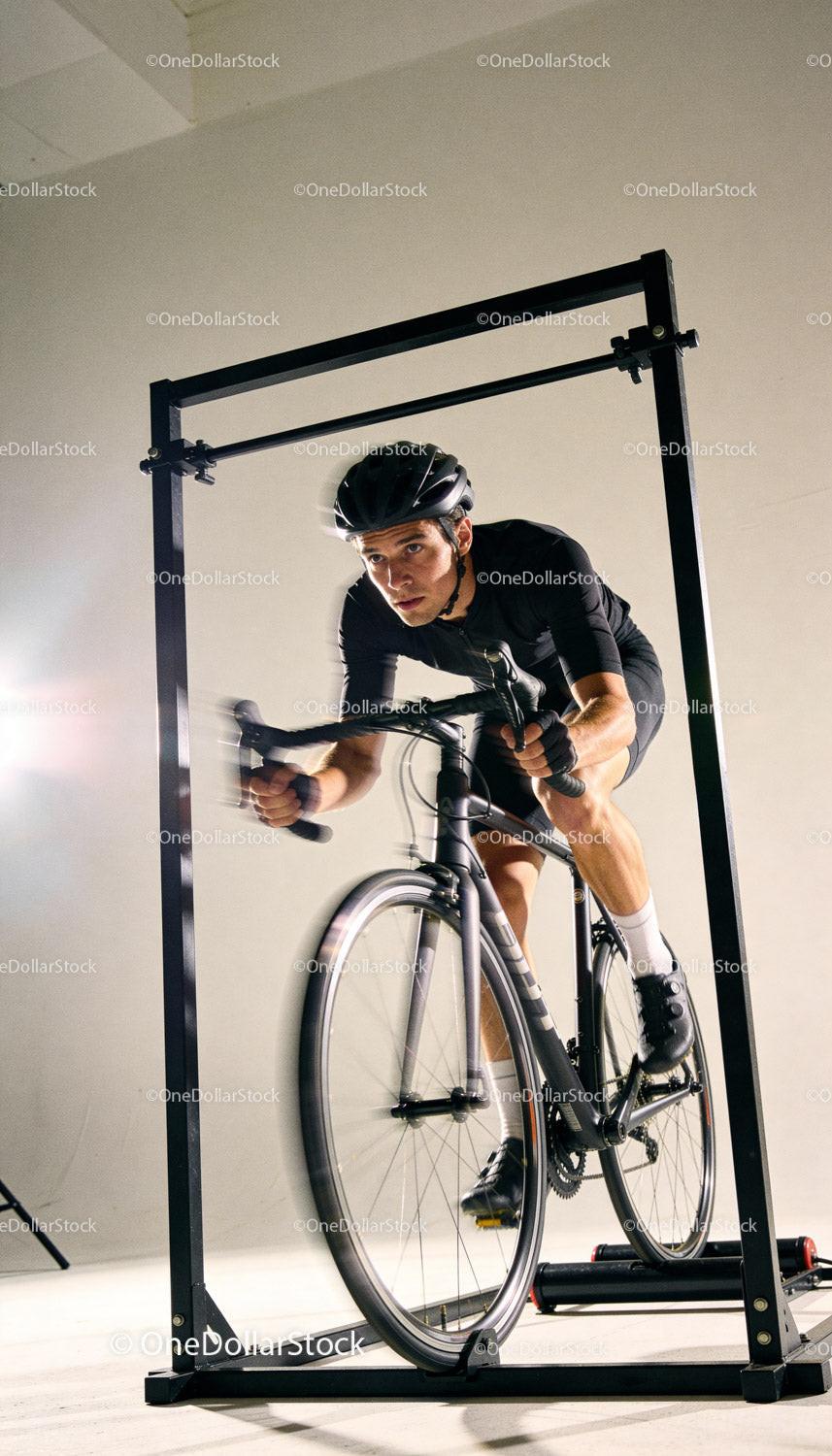 Focused cyclist training indoors on stationary bike trainer