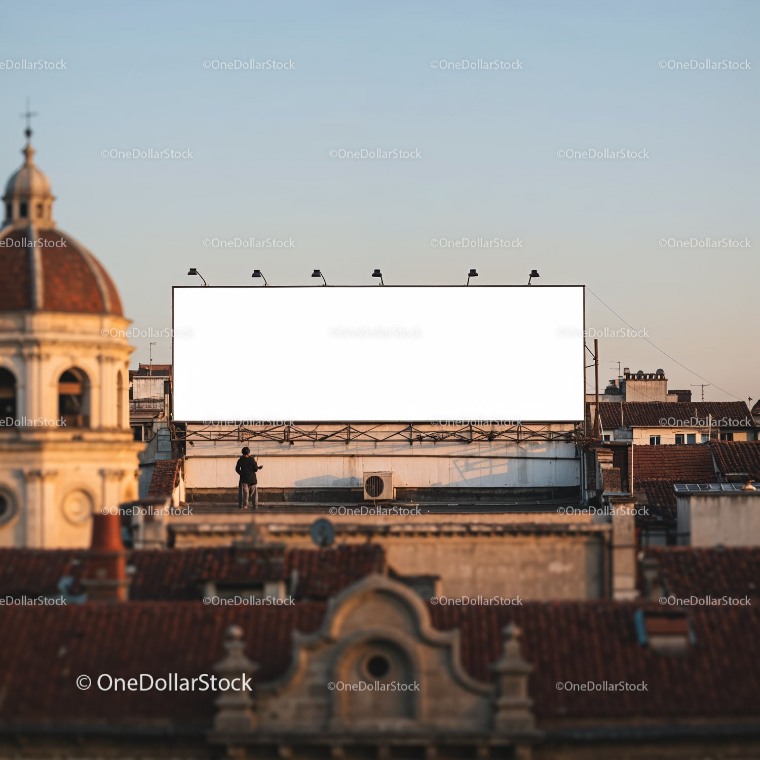 Duży, pusty billboard nad dachami miast o zachodzie słońca