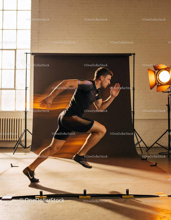 Athlete sprinting with dynamic motion blur in studio