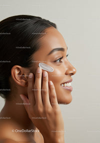Young Woman Applying Facial Skincare Product with Gentle Massage