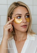 Young Woman Applying Gold Eye Patches for Skincare Routine