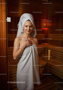 Young Woman Relaxing in Spa Sauna with Towel in Wellness Center