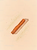 Single cinnamon stick with scattered cinnamon powder
