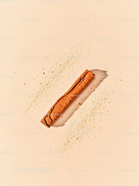 Single cinnamon stick with scattered cinnamon powder