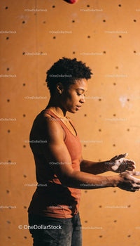 Focused woman preparing for indoor rock climbing session