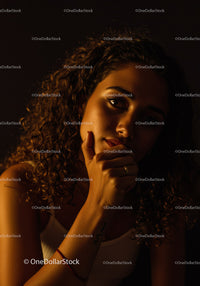 Thoughtful woman illuminated by warm soft light