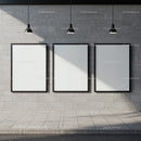 Three blank posters on concrete wall under pendant lights