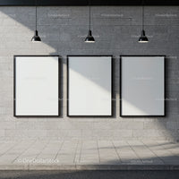 Three blank posters on concrete wall under pendant lights
