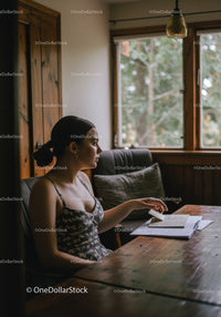 Young Woman Sitting at Desk with Notebook in Cozy Home Office