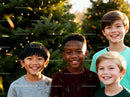 Joyful kids smiling outdoors with pine needles on clothes