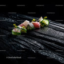 Elegant Sushi Platter Featuring Fresh Fish and Edible Flowers on Dark Wooden Surface