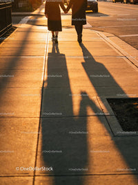 Couple holding hands walking in warm sunset light