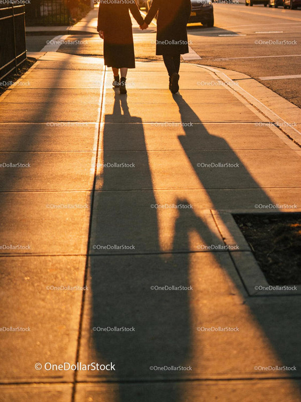 Couple holding hands walking in warm sunset light