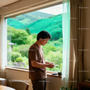 Man standing by window enjoying peaceful garden view