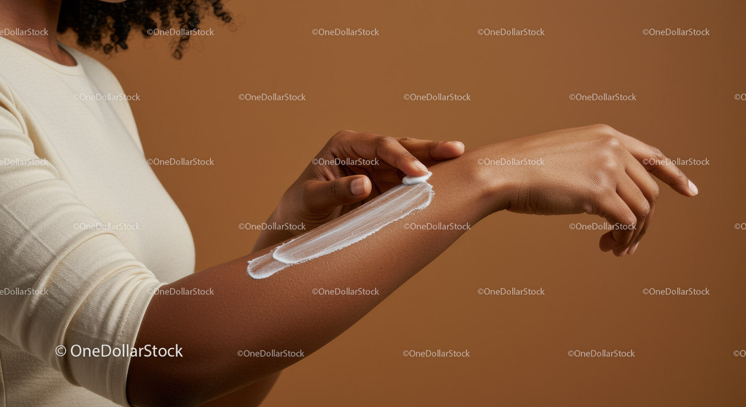 Close-up of a woman applying lotion to her arm showing healthy skin and skincare routine