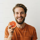 Happy Young Man Holding Fresh Grapefruit in Casual Orange T-Shirt