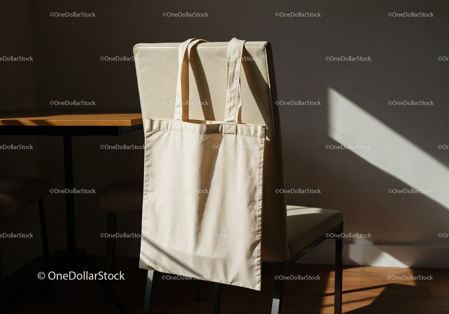 Minimalist beige tote bag hanging on chair in sunlight