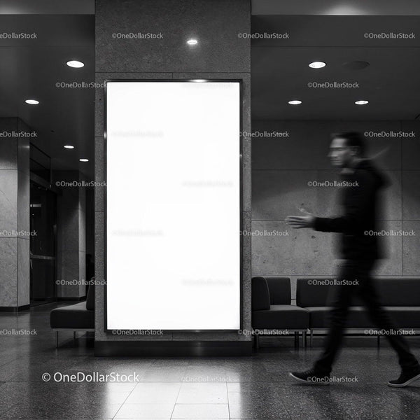 Rozmyty biznesmen przechodzący obok pustej miejskiej reklamy świetlnej