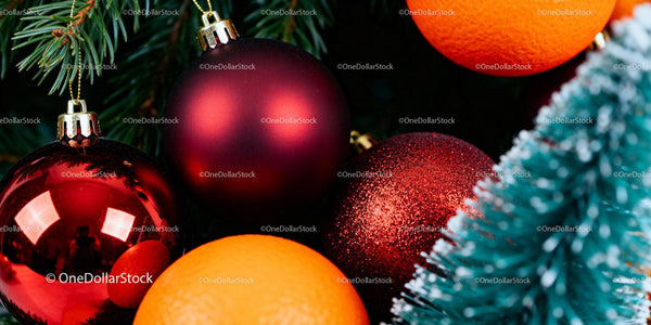 Close-up of red Christmas ornaments and fresh oranges