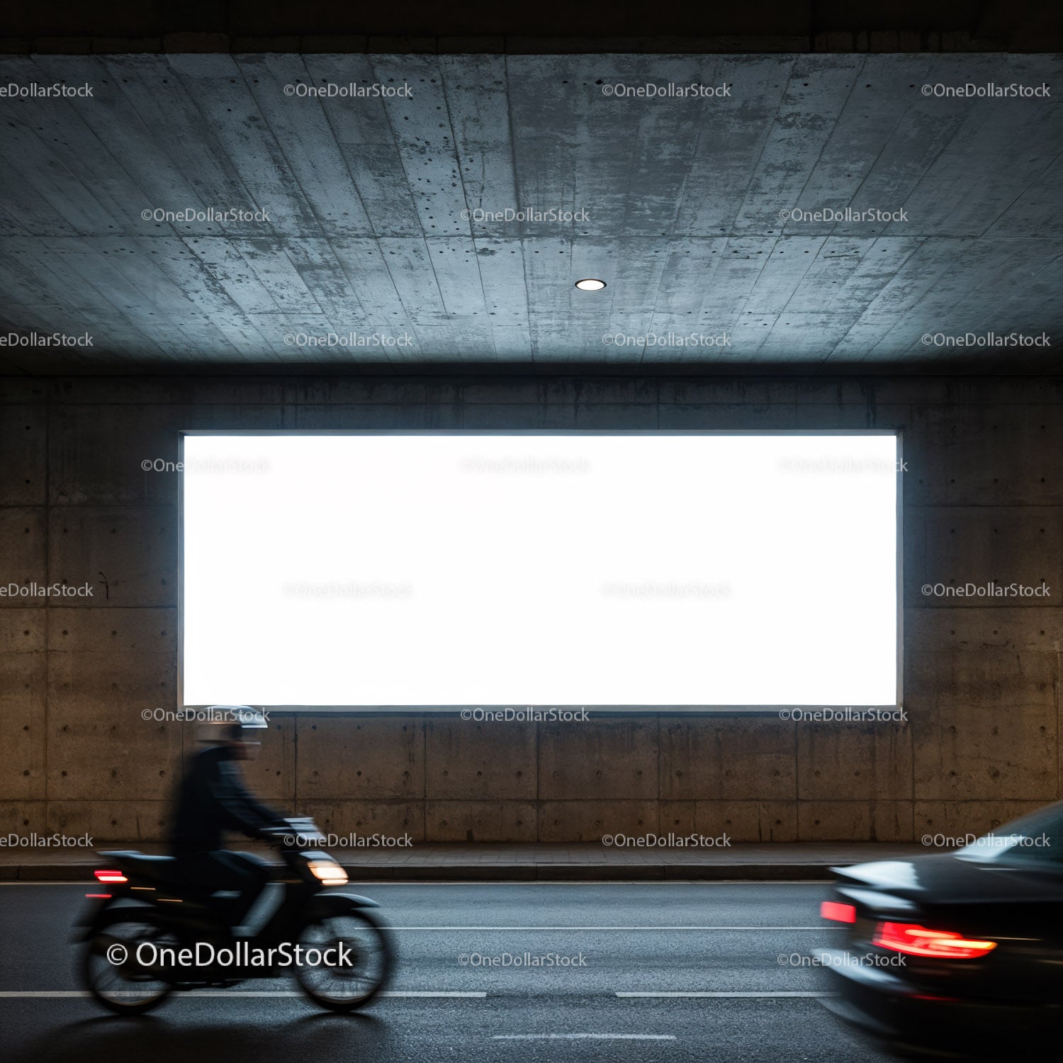 Motocyklista i samochód przejeżdżają pod miejskim betonowym tunelem