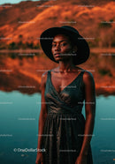 Elegant Black Dress and Wide Brim Hat Woman by Lake at Sunset
