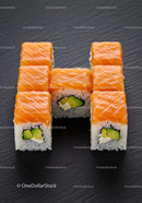 Fresh salmon avocado sushi rolls on black slate