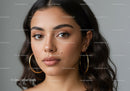 Elegant Female Portrait with Brown Eyes, Wavy Hair and Gold Earrings