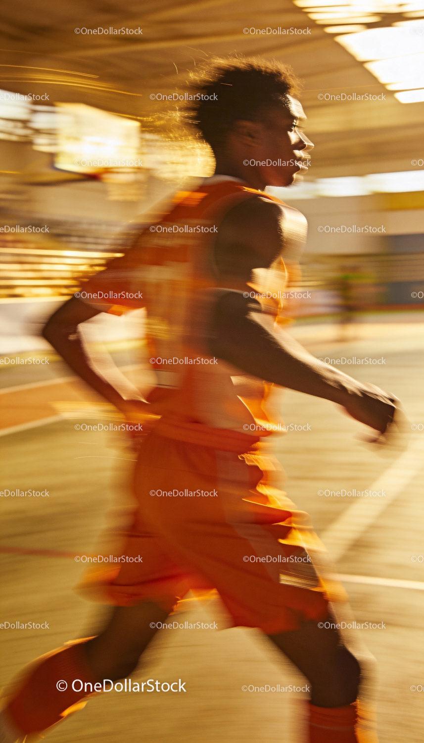 Dynamic basketball player sprinting on indoor court