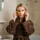 Woman Applying Gold Under-Eye Patches in Spa Setting