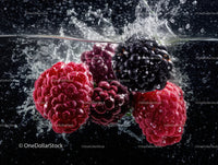 Fresh Raspberries and Blackberries Splashing in Water