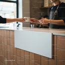 Barista handing a cup of coffee over counter in cafe