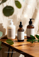 Natural skincare products with green leaves on wooden table