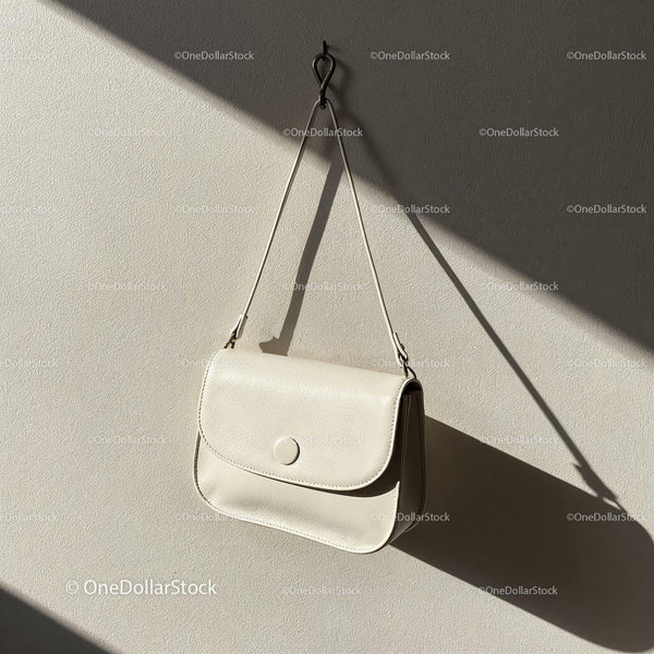 Minimalist white leather handbag hanging on wall JPG Mockup Image