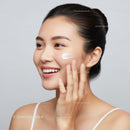 Woman Applying Moisturizing Cream on Cheek for Beautiful Radiant Skin