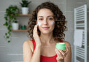 Young Woman Applying Moisturizer in Bathroom