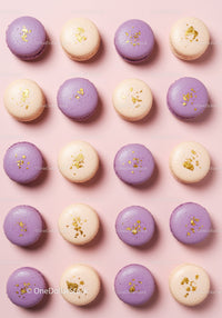 Purple and beige macarons with gold flakes on pink background