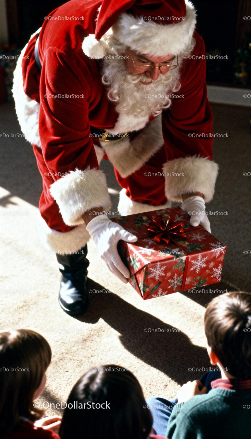 Santa Claus Giving Christmas Gift to Kids Indoors