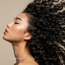 Profile of woman with flowing curly hair and smooth skin