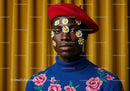 Portrait of man with daisies on face and vibrant outfit