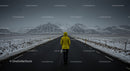 Lonely Traveler in Yellow Jacket on Snow-Covered Road