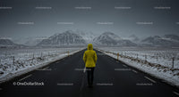 Lonely Traveler in Yellow Jacket on Snow-Covered Road