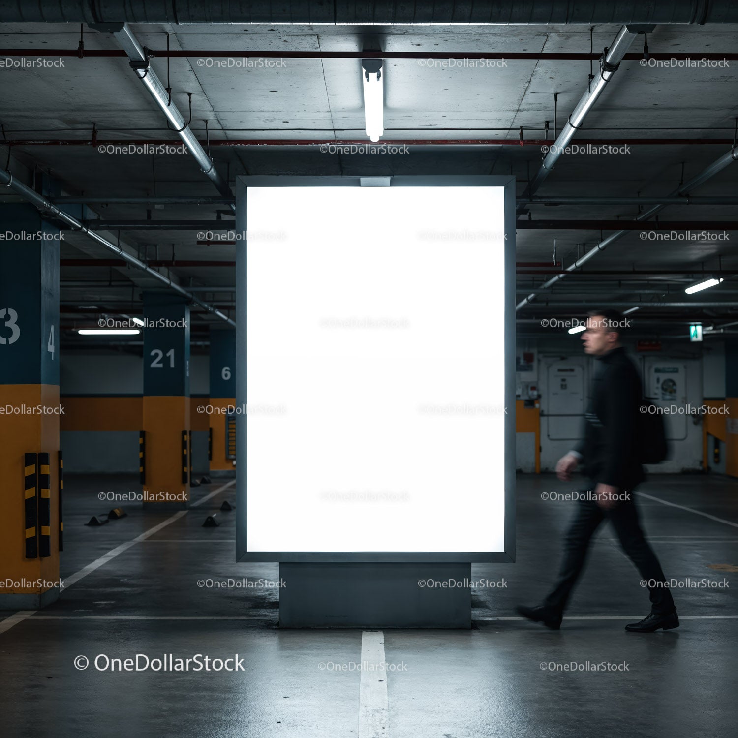 Mężczyzna przechodzący obok oświetlonego billboardu w podziemnym garażu