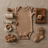 Neutral toned baby clothing and accessories flat lay